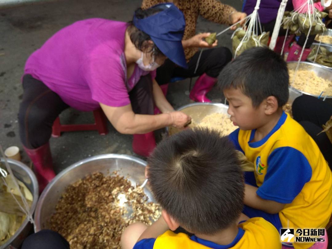 ▲潮洋村、張厝村社區民眾及潮洋國小師生義工媽媽旁邊學綁粽子，準備熱騰騰的美食和湯品迎接虔誠的香客，希望香客們飽餐一頓，補足體力，充滿一股濃濃復古風和人情味。（圖／記者陳雅芳攝，2018.03.29）