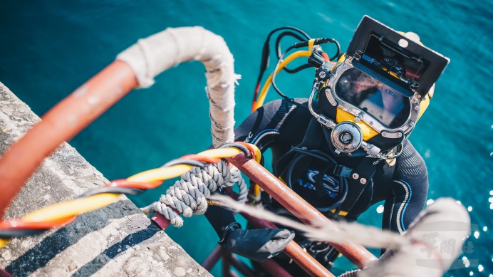 ▲ 任毅上士頭戴17B頭盔，身著氣瓶，謹慎的步入水中。（軍聞社記者陳軍均攝）