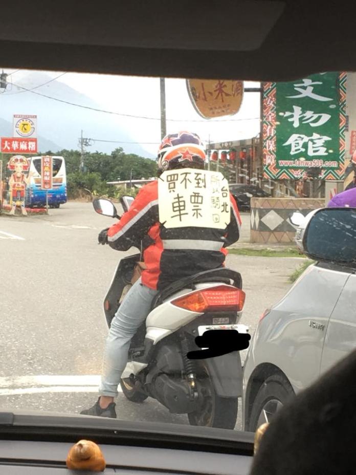 ▲一名騎士背著「買不到車票所以騎車回台北」的海報在台 9 線上狂飆。（圖／翻攝自「花蓮人」臉書社團）