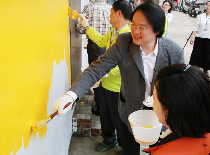 ▲基隆市長林右昌今（18）日與居民及參與的NGO團體代表，一同為建物牆面漆上暖黃色。（圖／基隆市政府提供）