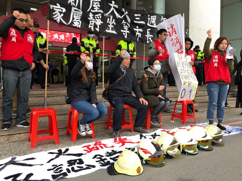 ▲2015年桃園新屋保齡球館大火造成6名消防員不幸身亡，殉職消防員家屬與消防員工作權益促進會成員6日在桃園市政府前靜坐抗議，要求市長鄭文燦出面對話。中央社記者吳睿騏桃園攝107年2月6日