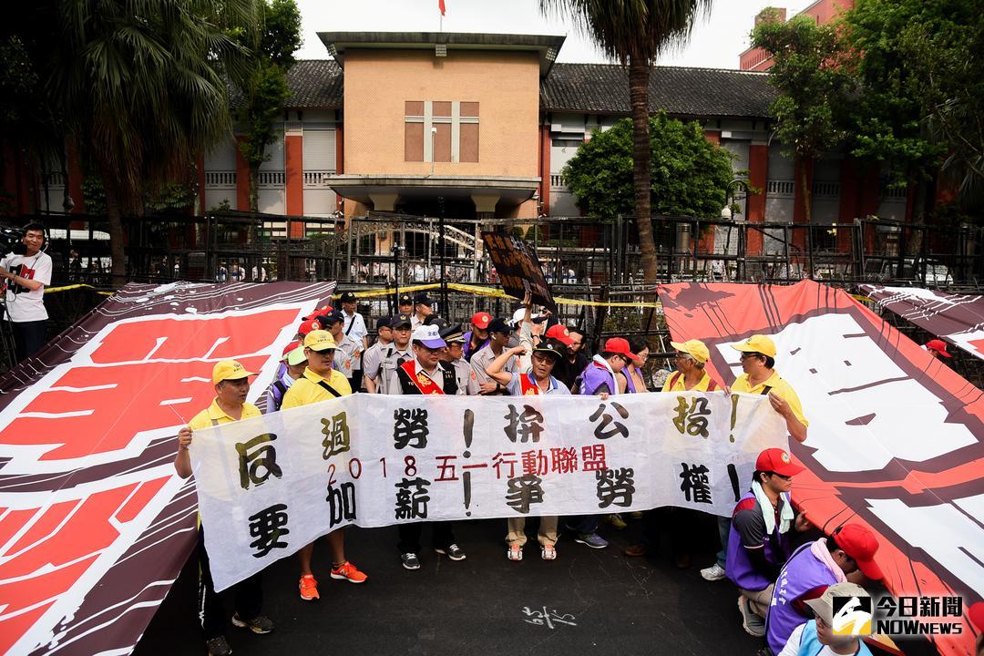 ▲中選會通過立委選區變更案，高屏各減一席、台南竹縣各增一席。圖為五一勞工大遊行，民眾在立法院門口拉起布條呼喊口號。（資料照／記者陳明安攝）
