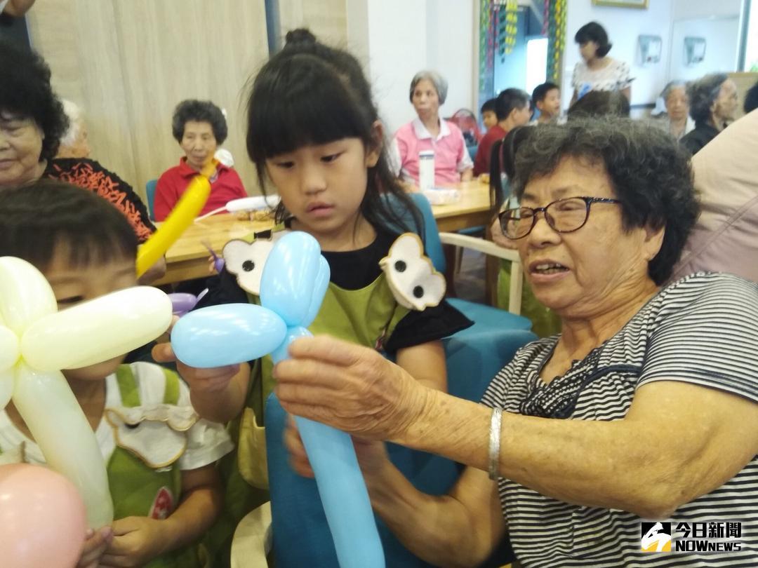 ▲母親節前夕，一群幼兒園小朋友到北斗日照中心和長輩互動，長輩熟練的折出造型氣球送給小朋友，還與機器人「阿寶」玩遊戲，現場玩的不亦樂乎。（圖／記者陳雅芳攝，2018.05.11）