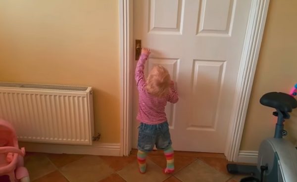 小女孩想要開門進去廚房。（圖／YouTube）
