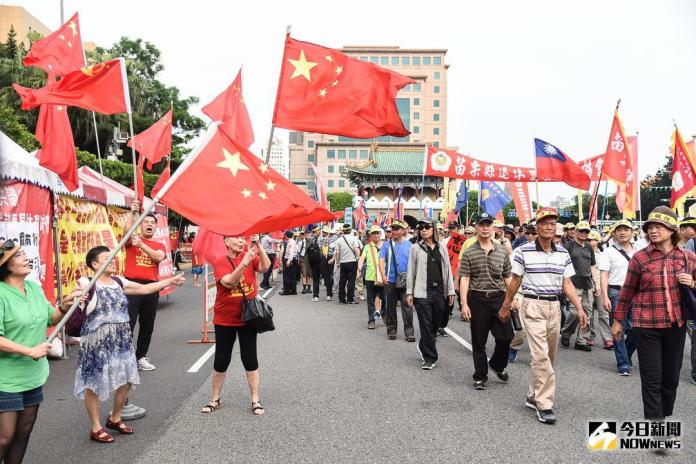 ▲「警消不服從」遊行時，中華愛國同心會民眾在一旁揮舞五星旗表達訴求。（資料照／記者陳明安攝）