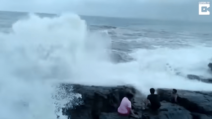 ▲ 2 男 1 女在海邊自拍，怎料一個大浪突然打上來，其中一名男子瞬間被沖走慘死。（圖／翻攝自youtube影片）