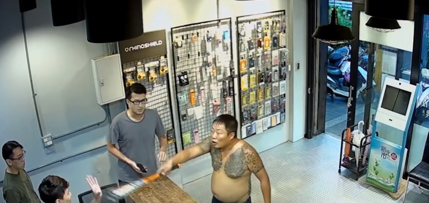 ▲一名半裸的刺青男子不滿手機在維修 8 個月後螢幕故障，竟堅稱是店家維修時弄壞的，要求店家負責，甚至還摔椅子、持球棒作勢打人。（影片截圖／翻攝自爆料公社 , 2018.07.21）