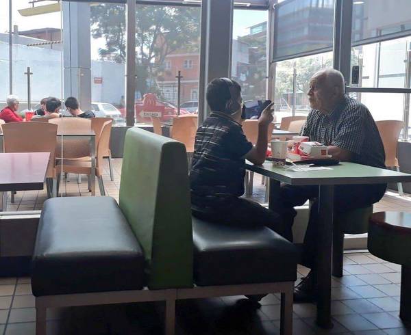 ▲爺爺帶孫子到麥當勞吃漢堡，但孫子卻只顧打電動，爺爺只好隔著 3C 產品靜靜地看著孫子。（圖／翻攝自推特 , 2018.08.19）