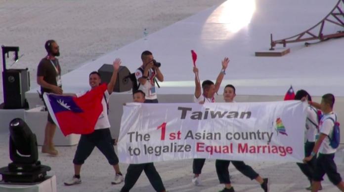 ▲巴黎同志運動會揭幕，在開幕遊行中，台灣隊帶著國旗上場，還有一塊長布幅以英語寫著「台灣，第一個婚姻平權合法的亞洲國家」。中央社記者曾依璇巴黎攝  107 年 8 月 5 日