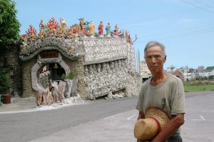 黃奇春先生與其一手打造的貝殼廟合影。（圖／彰化縣福興鄉公所）