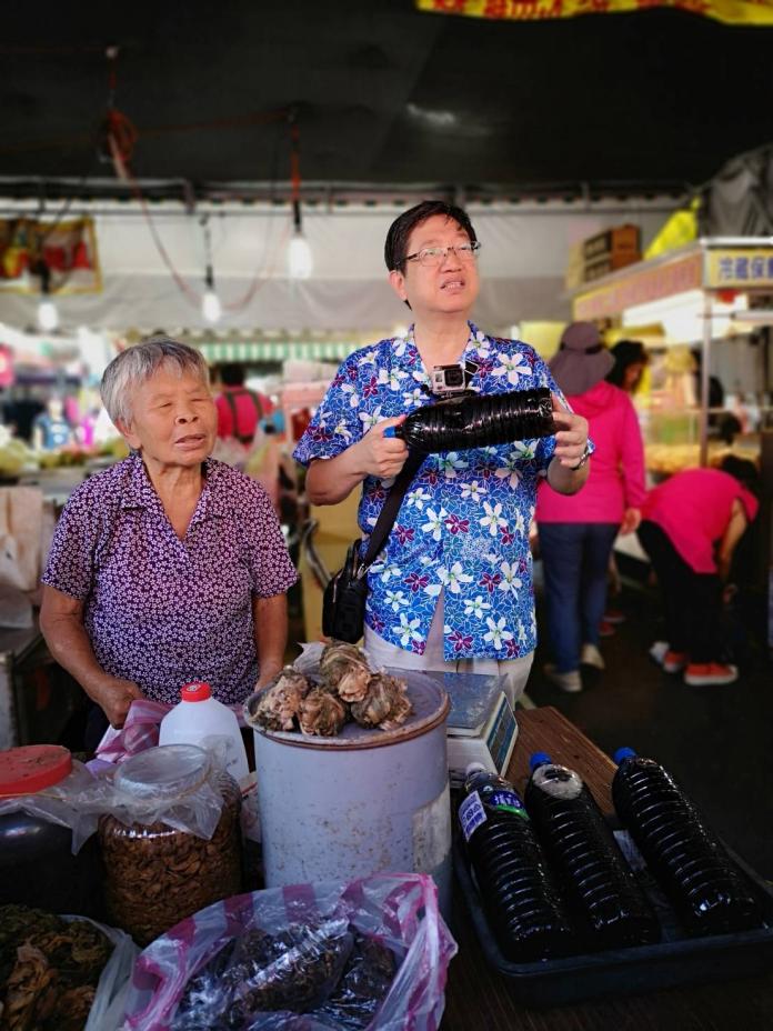 新竹縣長候選人楊文科（右）充當菜販協助叫賣，客家鄉親都感親切。