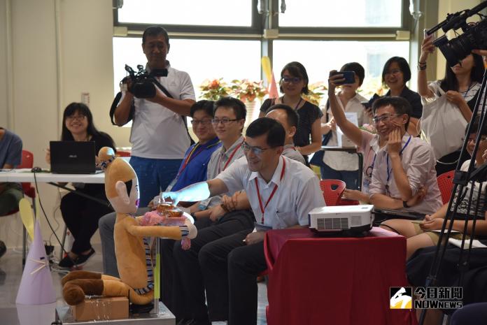 ▲吳剛機器人送月餅給南科管理局副局長何晉滄。(圖／南科自造基地提供)