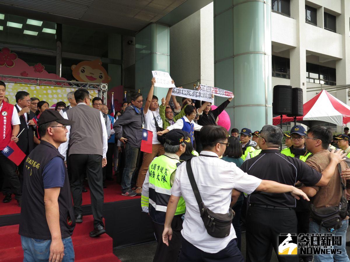 ▲桃園市長鄭文燦今早升旗典禮結束致詞時，遭到朱梅雪及十多名人士拉白布條高分貝抗議「藻礁已死，何來國慶？」。（圖／記者李春台攝, 2018.10.10）