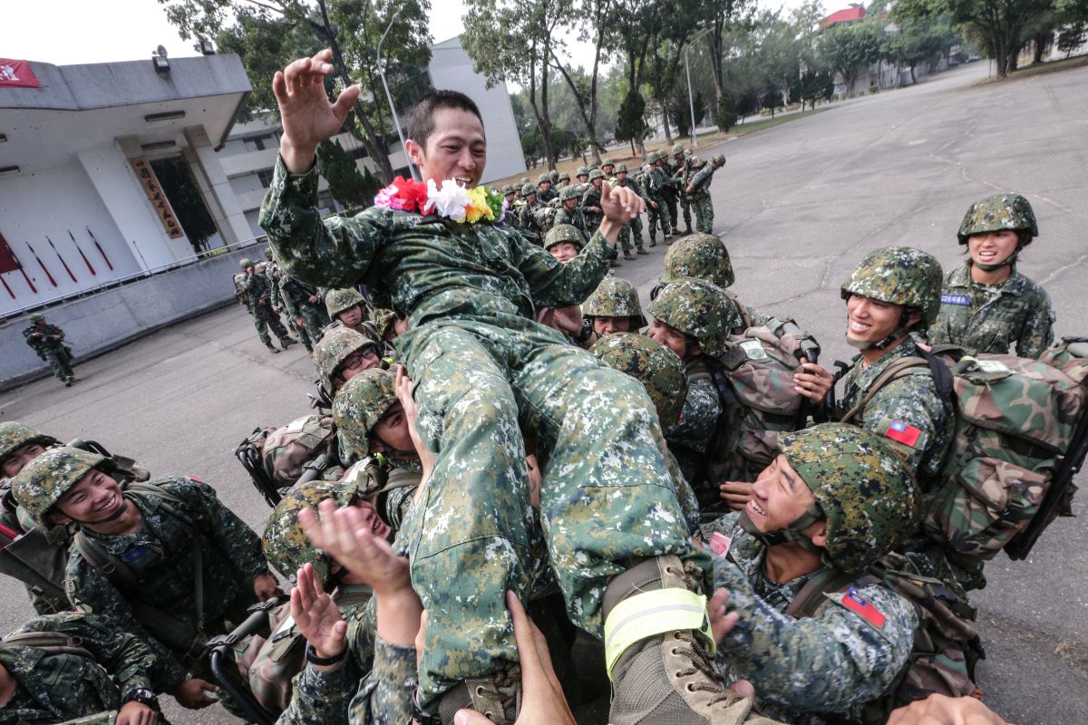 ▲陸軍特指部特2營延役的范鈞毅上士，在此次行軍任務中與同袍共同達成任務，連上官兵16日為他戴上花環，並開心地將他拋起（圖／軍聞社提供, 2018.11.16）