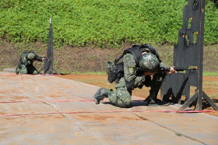 ▲憲兵「限制空間戰鬥競賽」中，參賽選手透過應變射擊障礙板的孔洞，完成T91步槍實彈射擊。（圖／軍聞社提供）