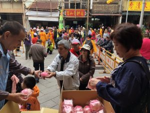 遶境前，廟方於廟埕發放壽桃與鹹光餅。（圖／連宜方攝）