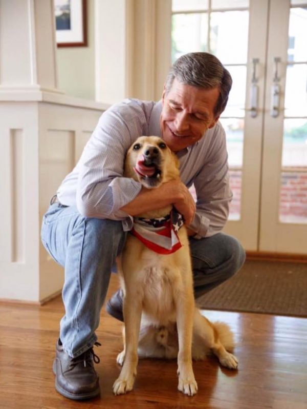 北卡羅萊納州的州長庫珀十分喜歡動物，也影響了他的孩子。圖中的狗狗班傑明是女兒希拉蕊收養的，因此庫珀總笑稱班傑明是他的狗孫子。（圖／facebook＠First Pets of North Carolina）