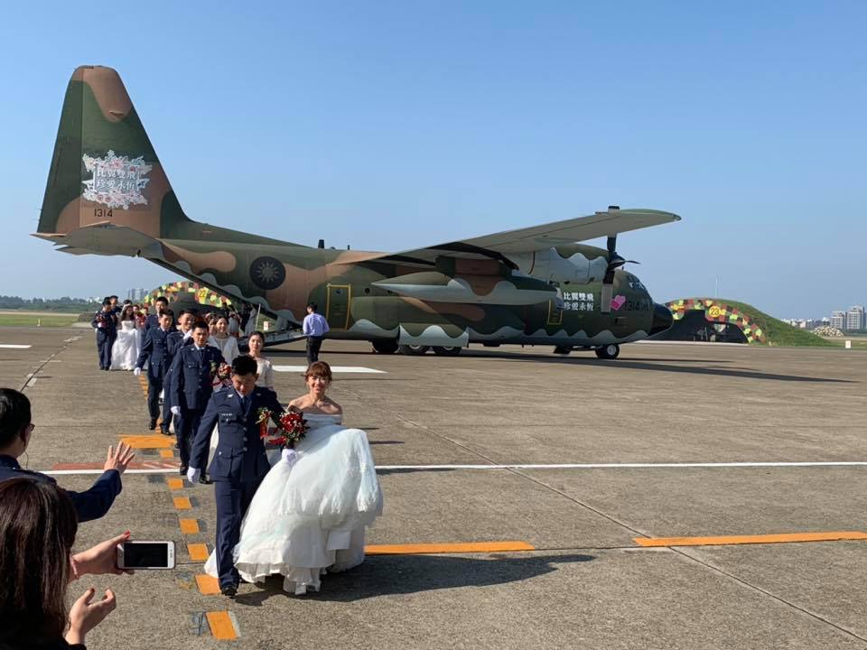 ▲70對新人依序自C-130運輸機走出來，步入空軍集團結婚典禮會場。（圖／翻攝自空軍司令部臉書）
