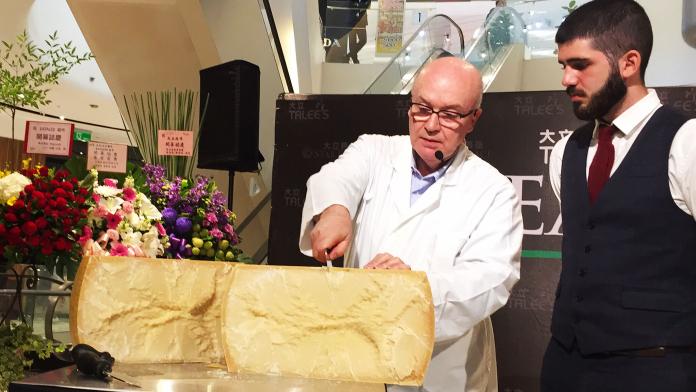 ▲義大利起司專家Stefano Basile現場展演切割，重達40公斤、要價15萬的帕瑪森乾酪。（圖／記者陳美嘉攝）