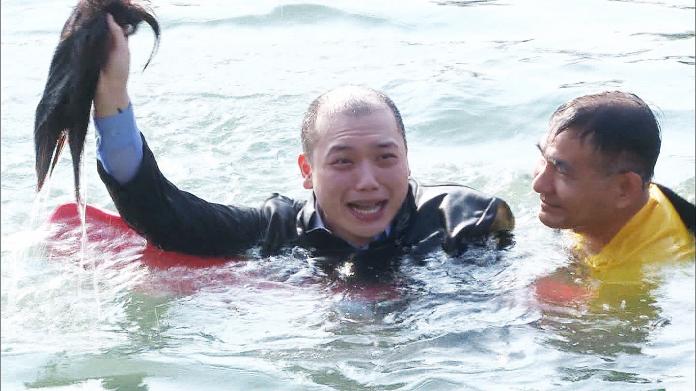 ▲阿虎直接往愛河猛然一躍假髮噴飛，讓現場眾人全笑翻。（圖／記者蔡佳宏翻攝,2018.12.14）