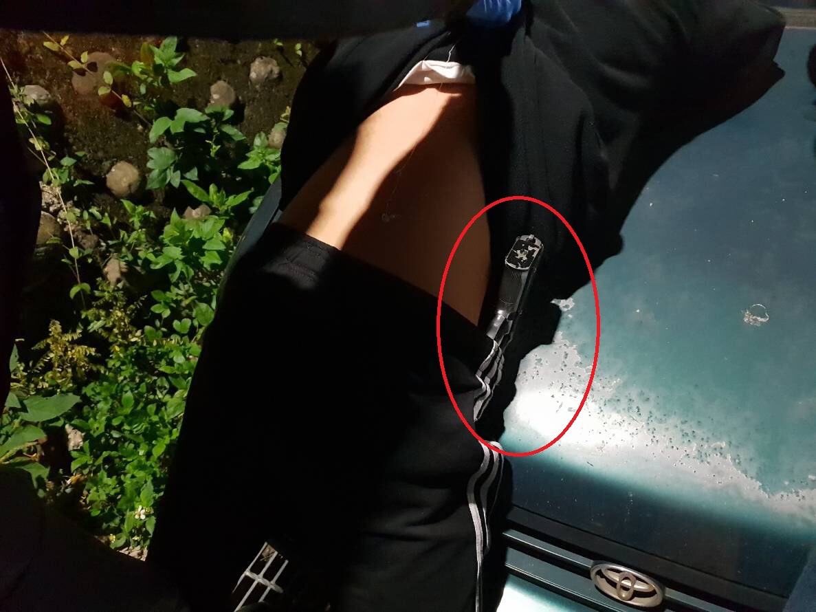 ▲落網的莊姓少年腰際插著制式克拉克手槍以及仿金牛座改造手槍，涉嫌在湖口鄉白晝街頭掃射。（圖／新湖分局提供）