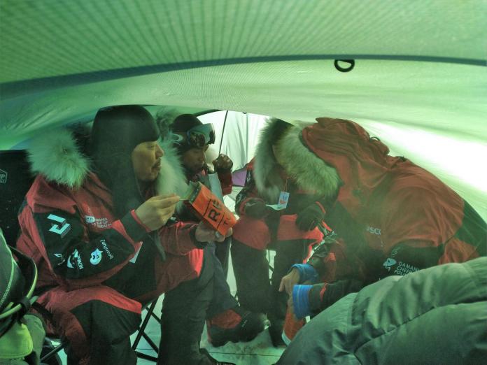 ▲南極長征隊在帳篷裡吃著乾糧與太空包食物，終於在12天後，終於吃到來自家鄉的美味（橘子關懷基金會提供）