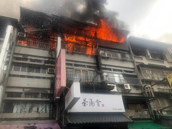 ▲員林市華成市場周邊店面傳出火警意外，一整排連棟店面鐵皮加蓋處冒出濃煙、竄出熊熊火舌，消防局出動雲梯車搶救。（圖／記者陳雅芳攝，2018.12.23）