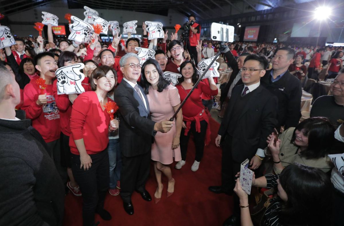 ▲台新金1月12日舉辦旺年會，董事長吳東亮攜夫人彭雪芬進場時，受到員工夾道歡迎，更開心與員工玩起自拍。（圖／台新金提供）