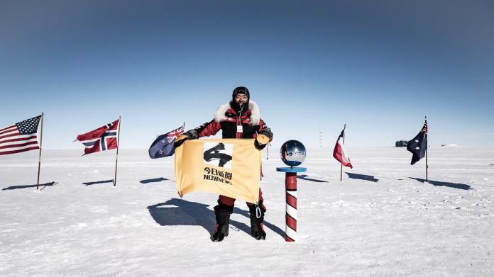 NOWnews跟著南極長征隊完整記錄每一段路程，最後的完攻南極點，隊長劉柏園舉起NOWnews旗幟，紀錄這值得歡欣的一刻。（圖／劉柏園提供）