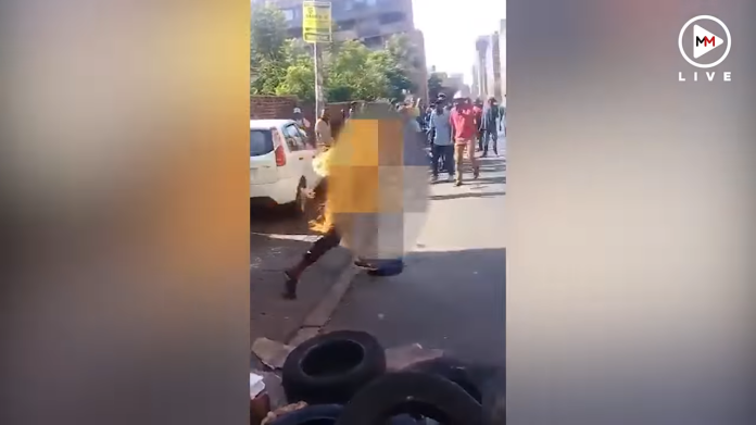 ▲南非約翰尼斯堡，兩名男性歹徒搶劫一名女子，被附近民眾逮住後，當街放火焚燒歹徒。（圖／翻攝自 Multimedia LIVE影片）