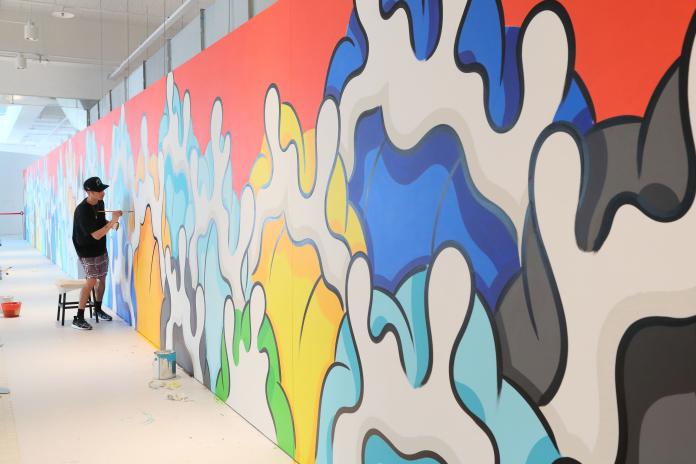 ▲來自夏威夷的Aaron Kai創作全世界最長海浪塗鴉藝術牆，總長66公尺長堪稱全世界最。（圖／台開集團提供）