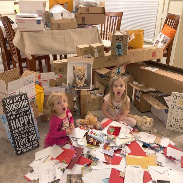可愛的小姊妹在粉絲寄來的禮物堆中擺出驚訝的表情。