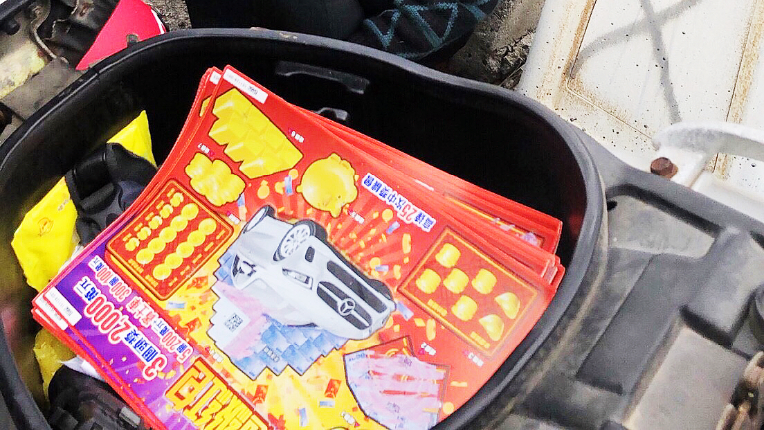 ▲警方在吳男的機車置物箱內查獲34張刮刮樂彩券。（圖／高市警局提供）
