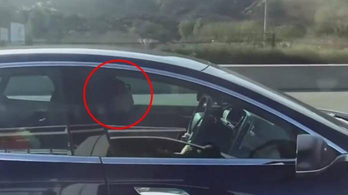 美國加州一名特斯拉駕駛邊開車邊睡覺。（圖／翻攝WTF!?推特）