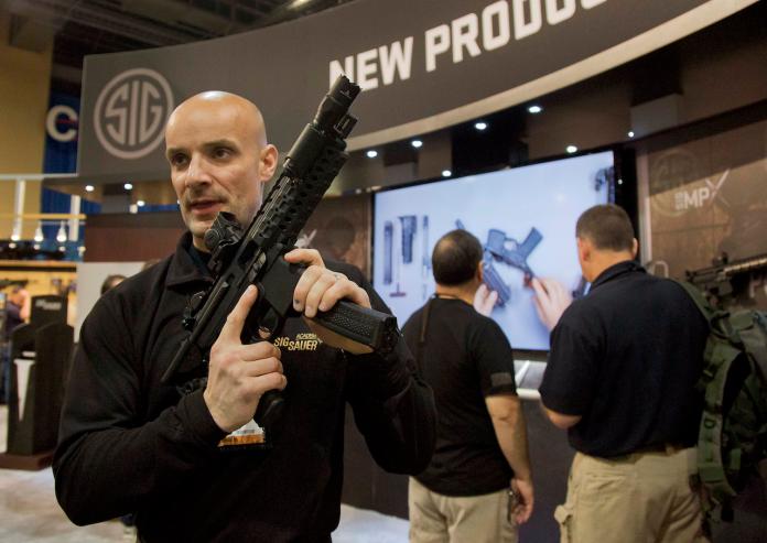拉斯維加斯槍展上，SIG SAUER槍廠人員展示MPX衝鋒槍。（圖 ／達志影像 ／美聯社）