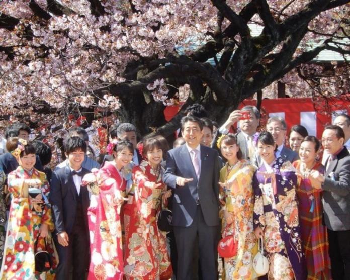 ▲日本首相安倍晉三在平成最後賞櫻大會，與人氣女子偶像團體「桃色幸運草Z」一起比招牌手勢。（圖／翻攝網路）