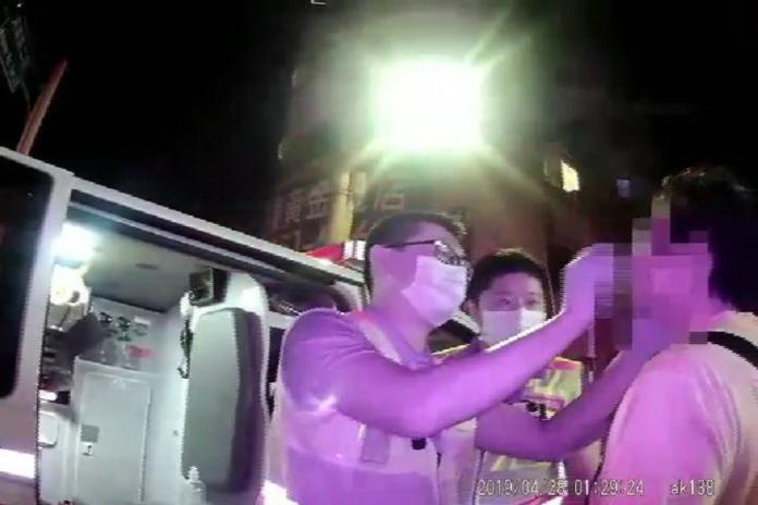 ▲救護人員替遭圍毆的周姓男子擦拭處理滿臉的鼻血（圖／警方提供）