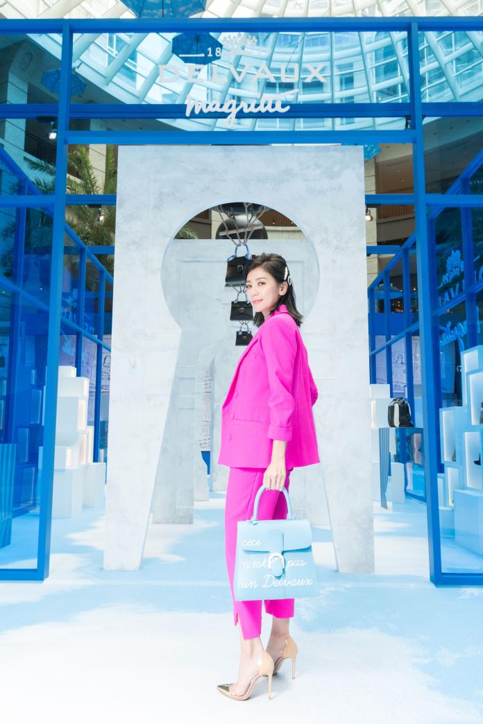 ▲女星賈靜雯身穿桃紅色套裝，搭配 DELVAUX René Magritte 系列 Brillant L’Humour 天堂藍中型牛皮肩背包，出席馬格利特系列特展。（圖／DELVAUX提供）