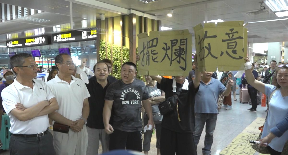 ▲不滿金門航空站無法提出有效的疏運計劃，滯金旅客拿著抗議紙板在航站內遊行吶喊「我要回家」。（圖／民眾提供）