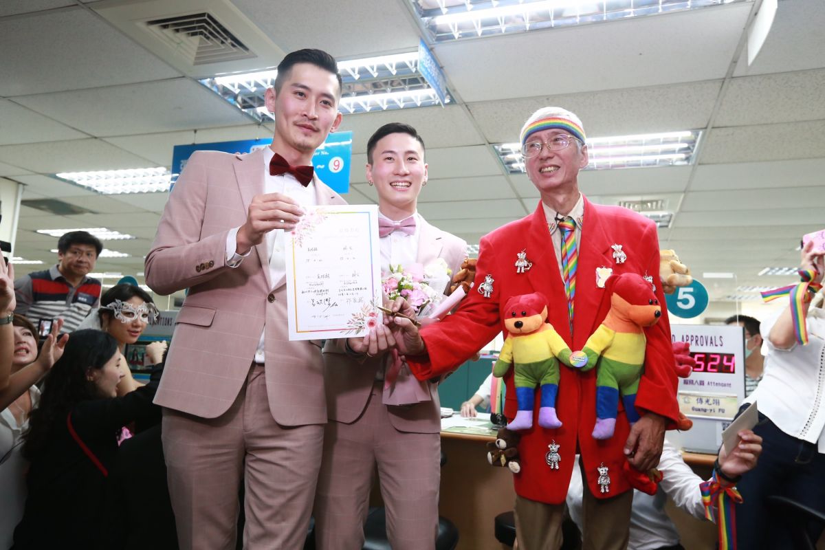 同志新人小玄（中）與小銘穿著粉色西裝步入會場，小玄哽咽表示，兩人已交往12年，能走到婚姻這一步仍覺得非常不容易。（圖／記者葉政勳攝）