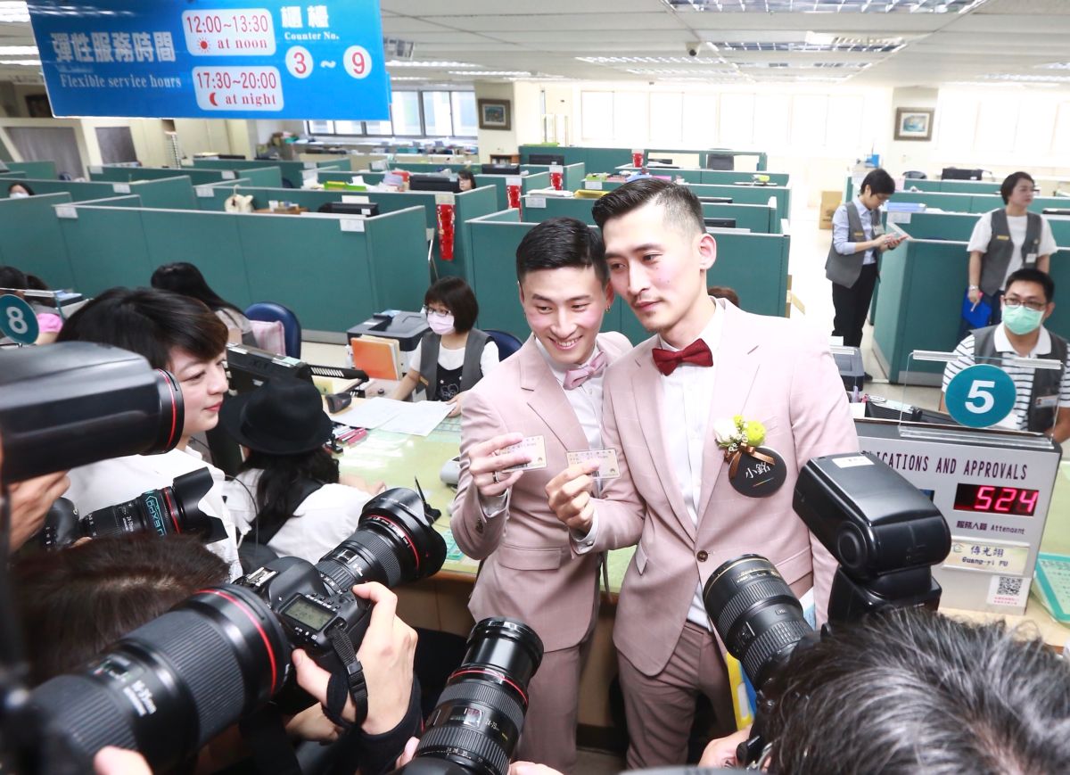 同志新人小玄與小銘穿著粉色西裝步入戶政事務所，成為信義區第一對登記的男同志伴侶。（圖／記者葉政勳攝）
