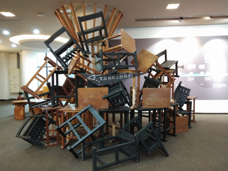 展覽現場還原當時學生堵住宿舍入口的課桌椅。（初聲／吳芝頤攝）