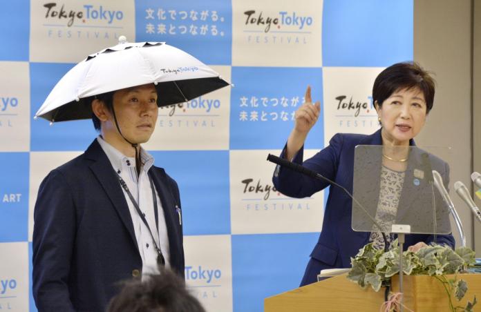 ▲東京都知事小池百合子向大眾展示斗笠傘。（圖／截自YouTube影片）