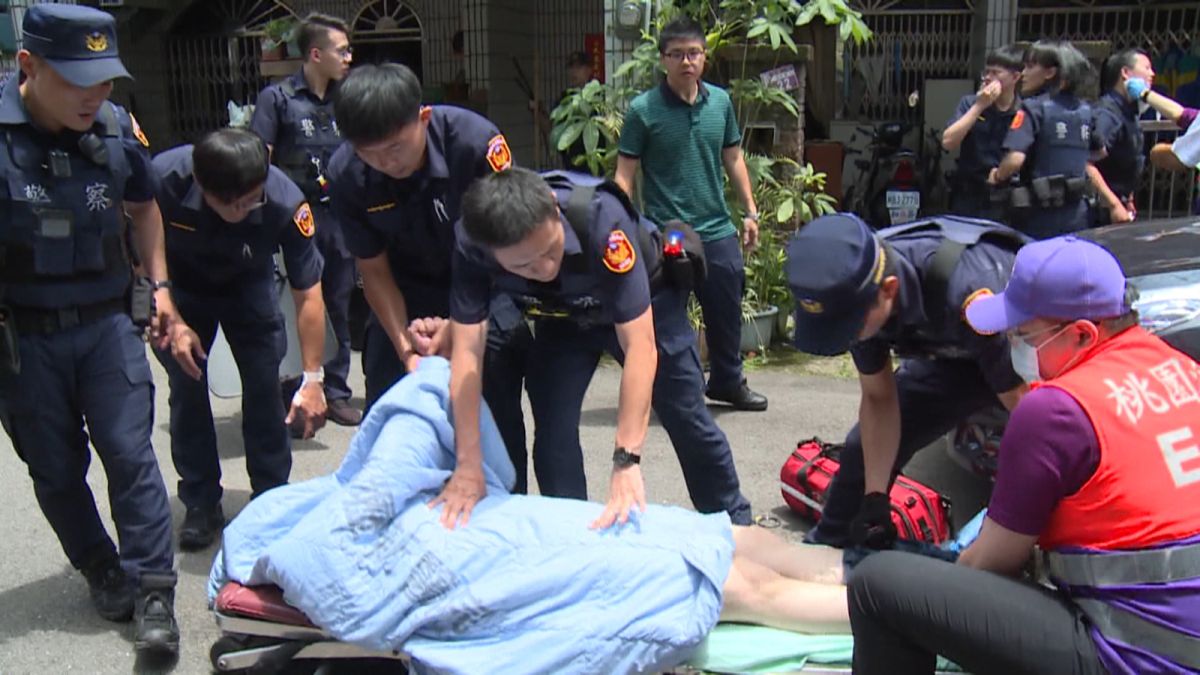 ▲情緒失控的張姓男子最後終於被警方制伏，被固定在擔架上帶走。（圖／記者李春台翻攝）