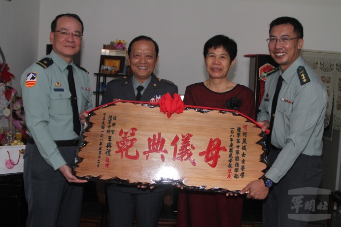 ▲ 陸軍第10軍團指揮官王中將表揚榮獲軍團模範母親殊榮的何燕娥女士，頒發「母儀典範」賀屏。（陸軍第10軍團提供）