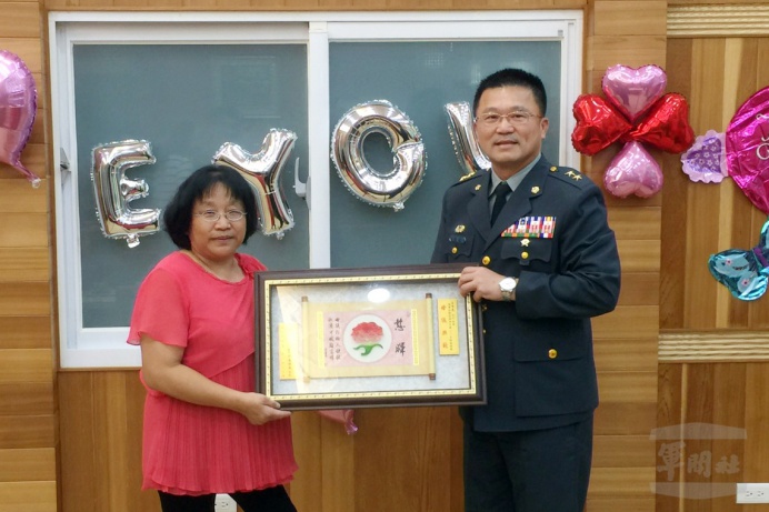 ▲ 陸軍後勤指揮部指揮官吳中將表揚模範母親王秀惠女士，親頒王女士賀屏及禮品，表達恭賀之意。（陸軍兵整中心提供）
