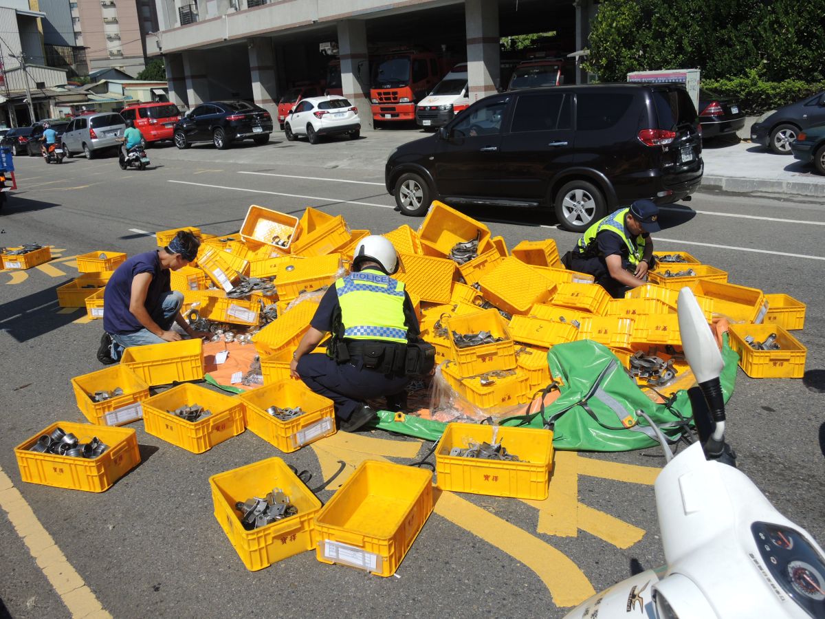 ▲彰化縣消防局前發生貨物散落在台一線南下車道上，員警頂著高溫，徒手幫忙撿拾金屬配件。（圖／記者陳雅芳攝，2019.06.05）