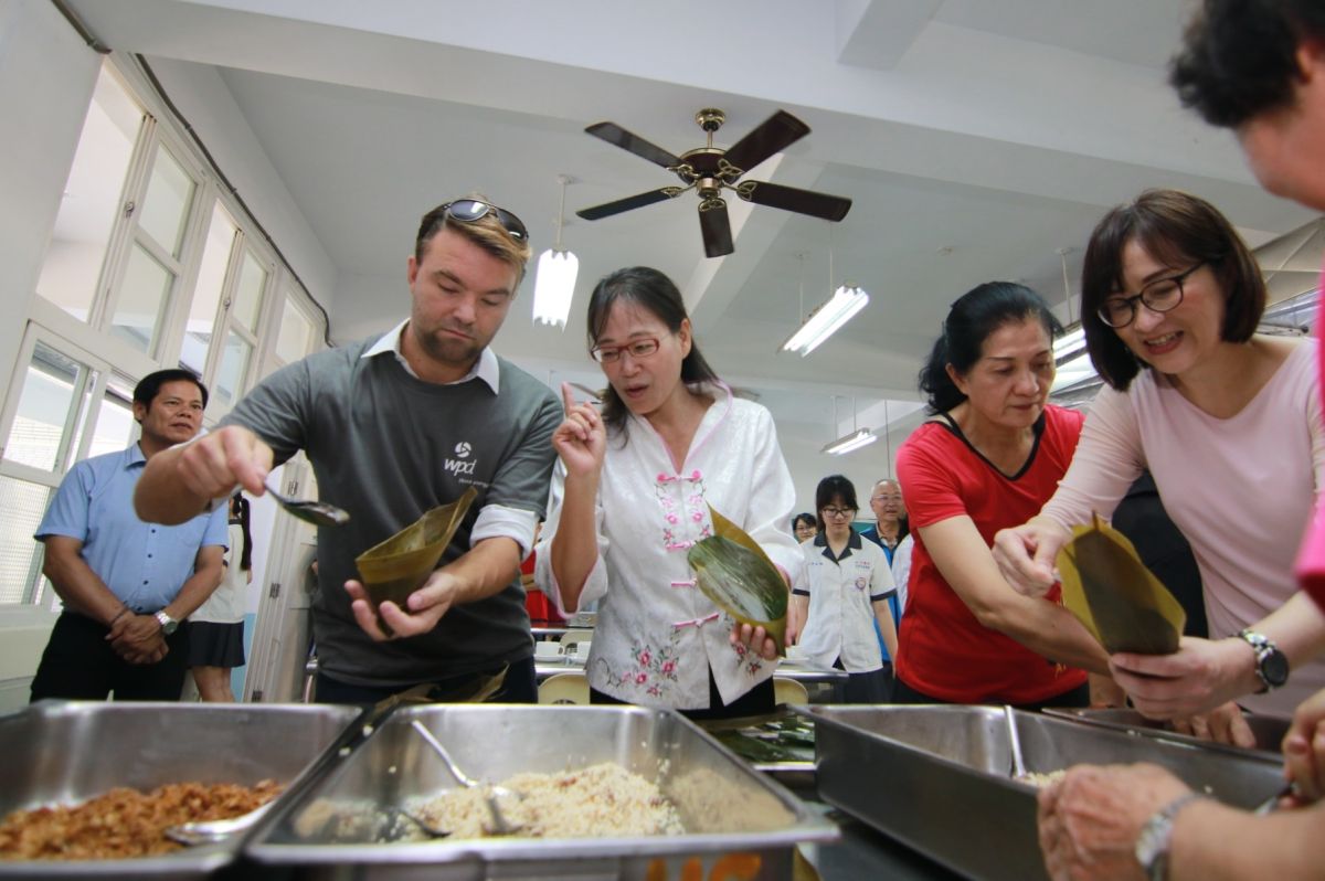 ▲謝淑亞小試身手指導阿兜仔學包肉粽。（圖／記者蘇榮泉攝，2019.06.05）