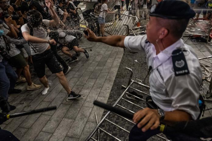 ▲鎮暴警察以警棍和胡椒噴霧企圖驅散民眾，部分示威者向警方丟擲瓶罐。（圖／翻攝自紐約時報）