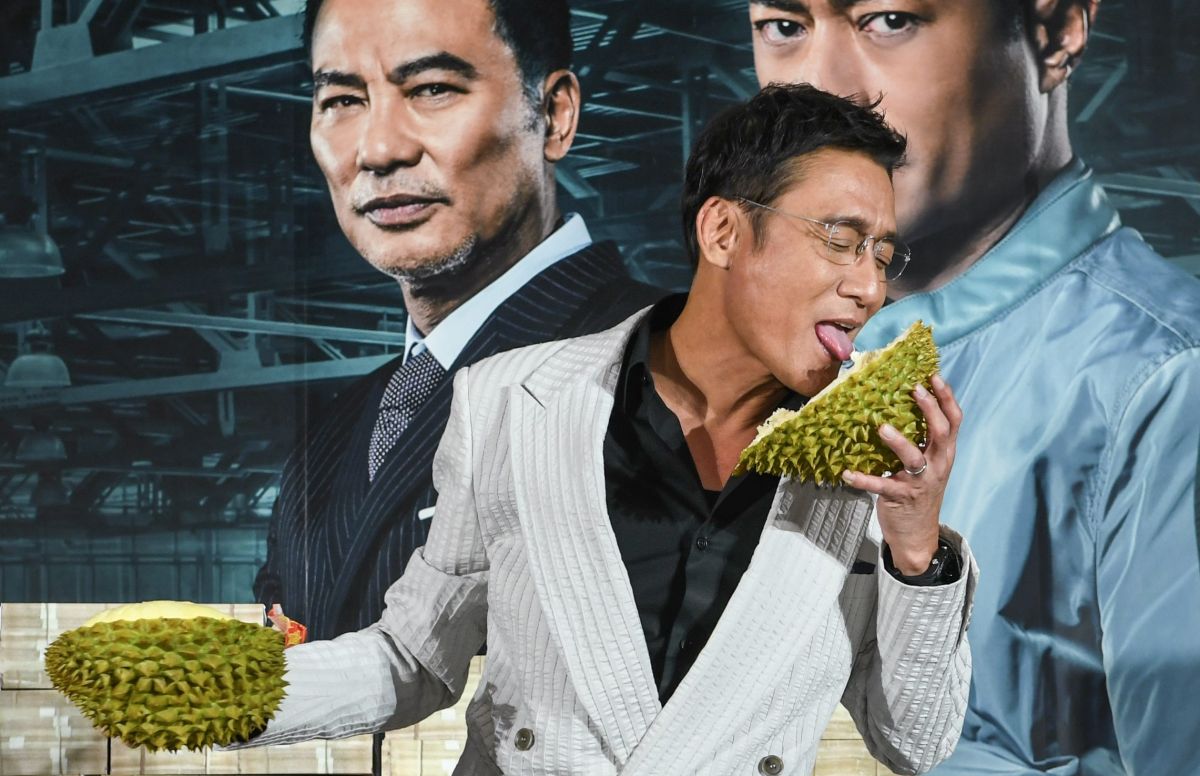 ▲梁家輝在記者會上舔榴槤。（圖／華映）